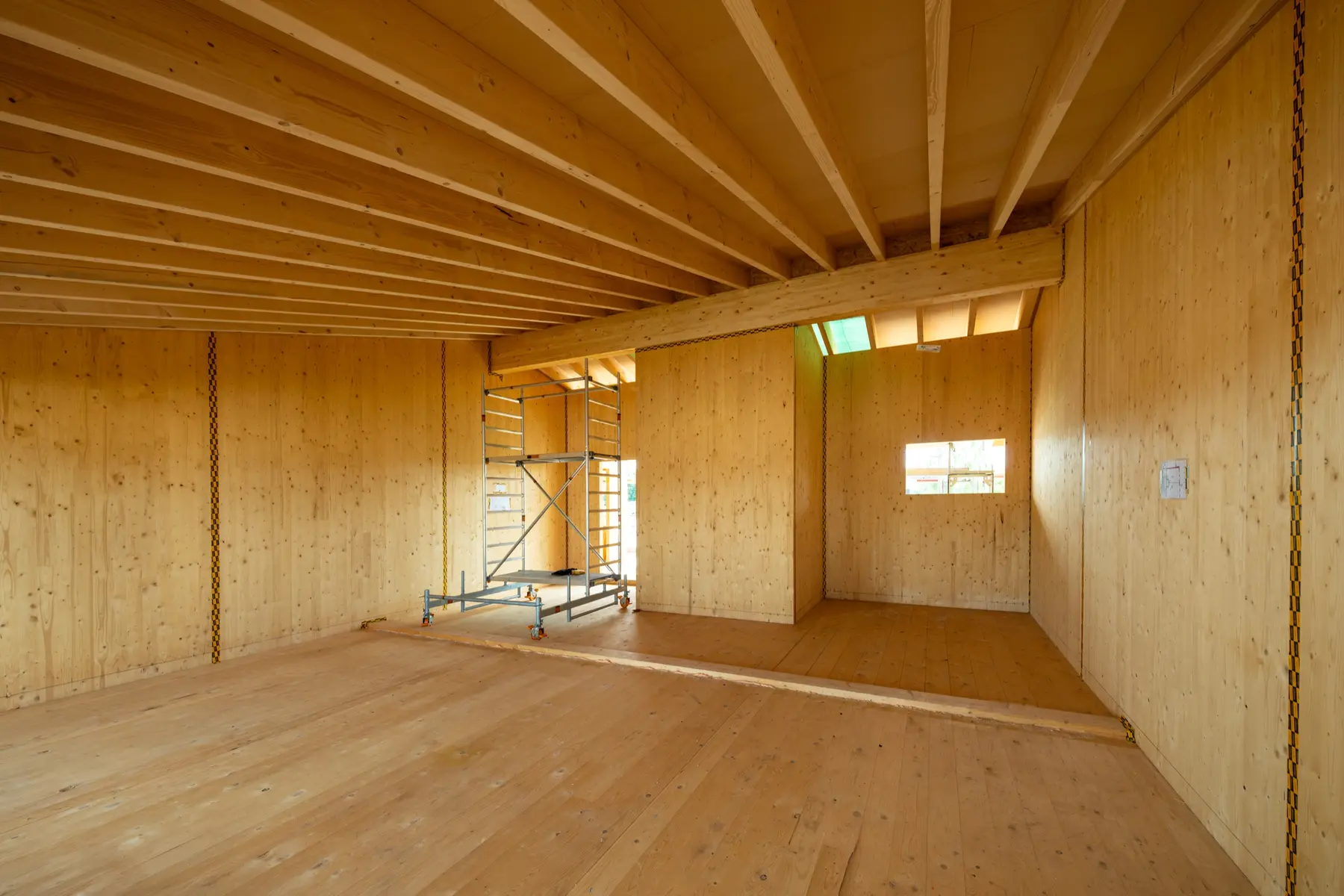Massivholz-Wohnraum mit großen Fenstern – energieeffiziente Gebäudehülle